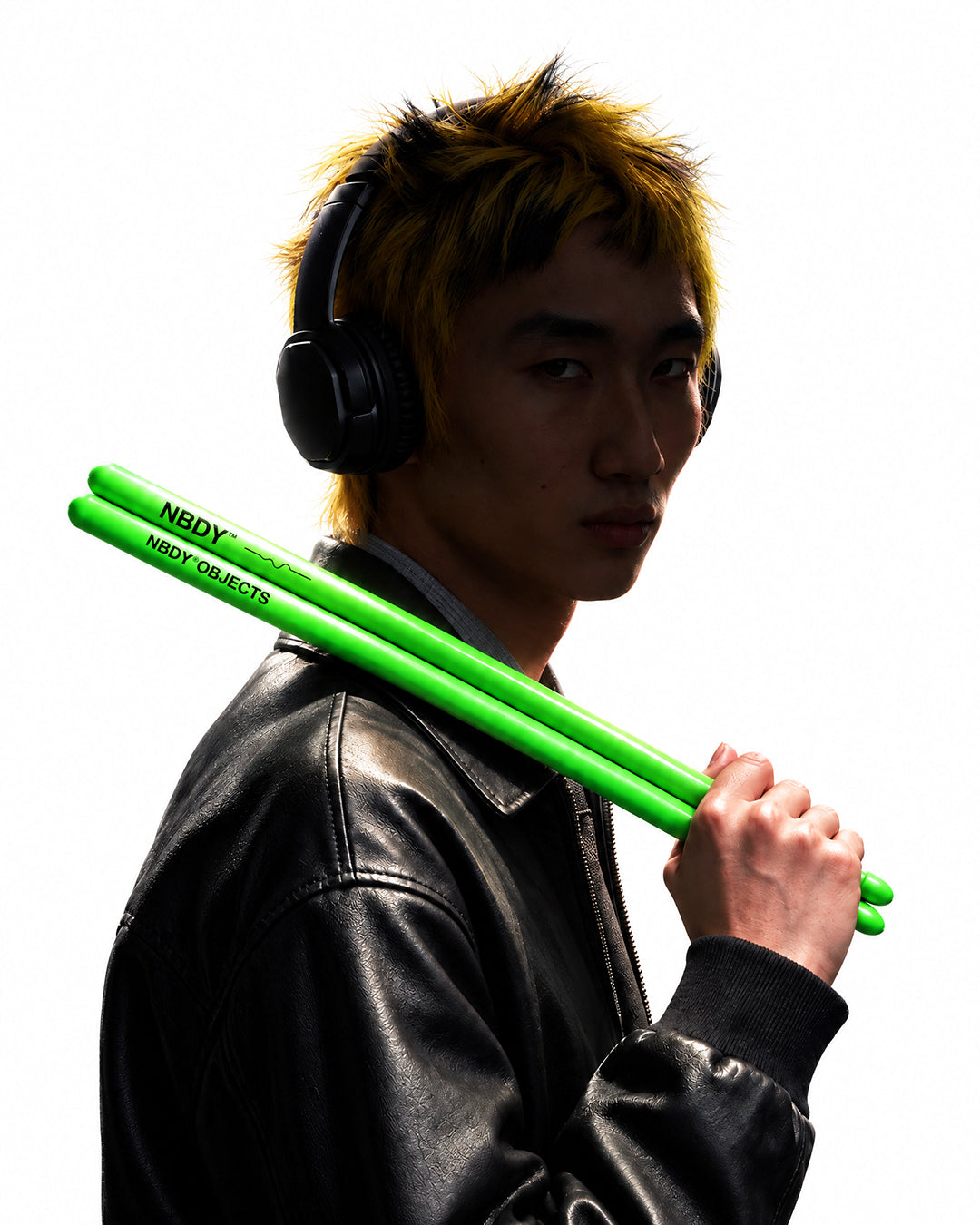 Model in headphones with NBDY drumsticks over his shoulder