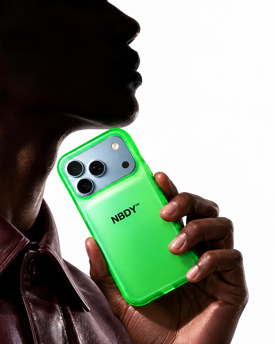 Model in profile holding an iPhone in the green NBDY case